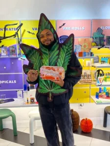 Man wearing a cannabis leaf Halloween costume inside Lady L Cannabis store