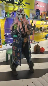 Person in a masked axe wielder Halloween costume inside Lady L Cannabis store